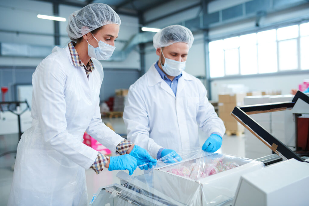 Confectionery Factory Employees In White Coats Packing Paper Box