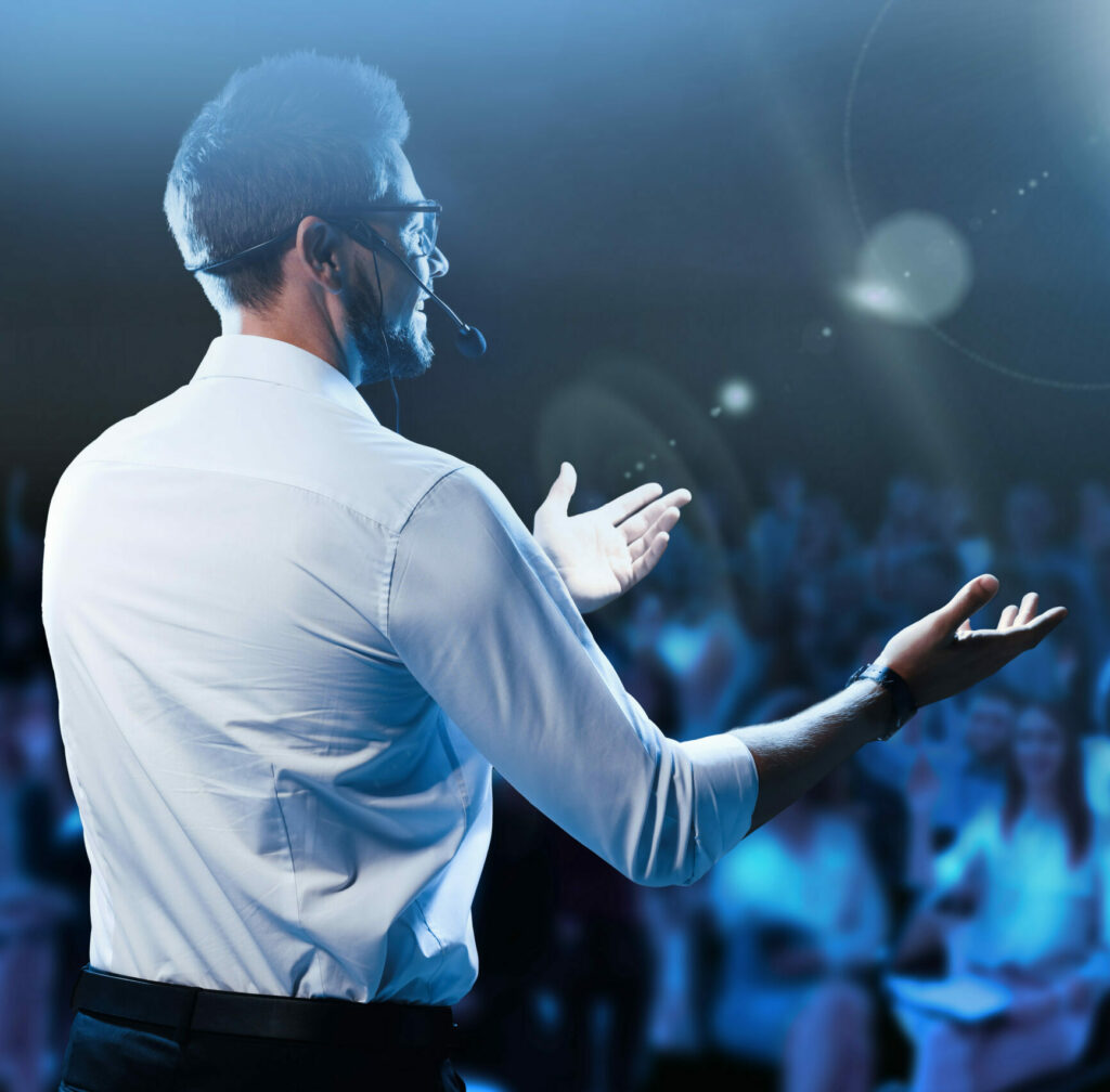 Motivational speaker with headset performing on stage