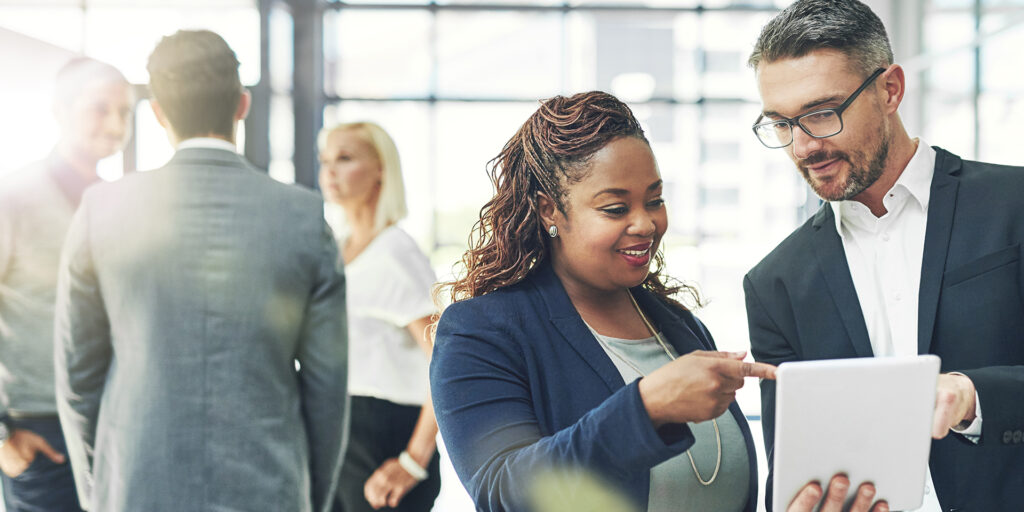 He trusts her business instincts. Shot of two coworkers talking together over a digital tablet in an office.