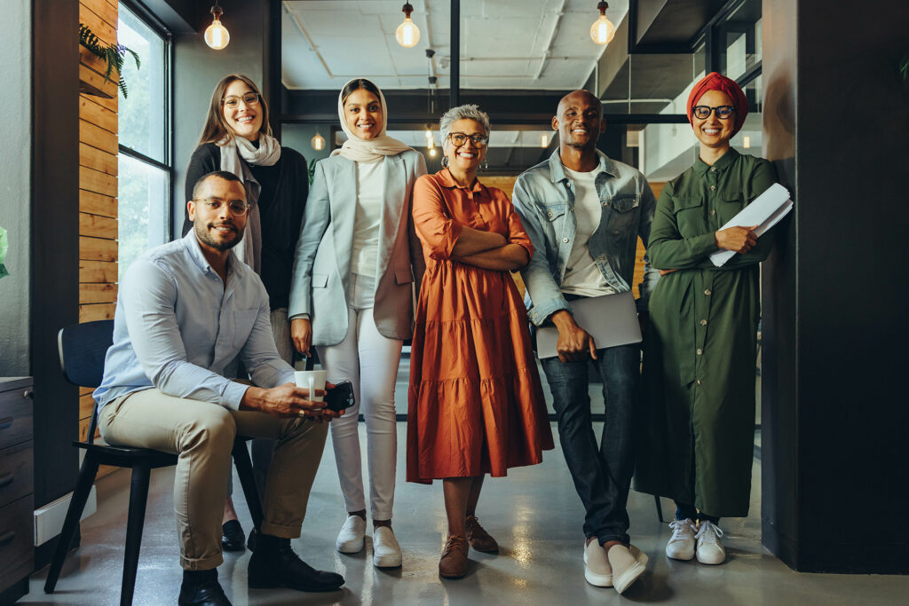 Multicultural business team smiling at the camera in an office